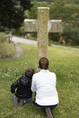 Mother and son in front of a cross clipart