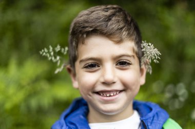 Kulaklarında çiçekler olan güzel çocuk