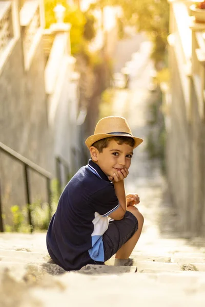 Portret van een schattige jongen met hoed op een trap — Stockfoto