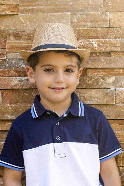 Carino ragazzo con cappello su uno sfondo di mattoni — Foto Stock