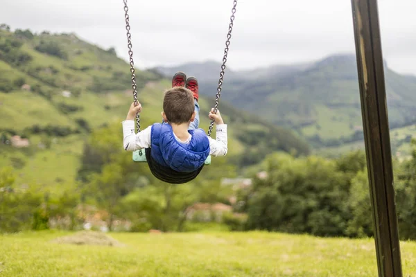Swinging child on the middle of a field — Stock Photo, Image
