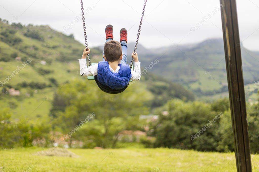 Swinging child on the middle of a field