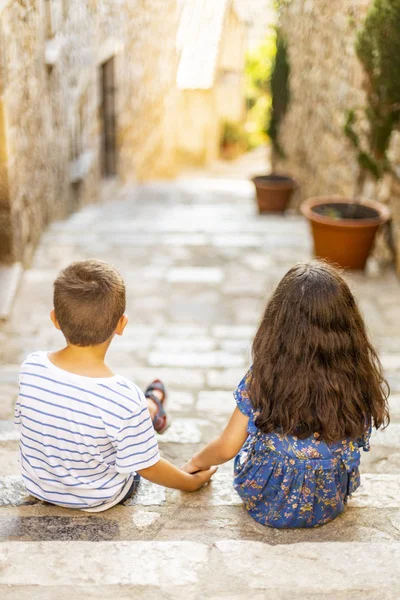 Twee kleine kinderen houden van haar handen op een zomerdag — Stockfoto