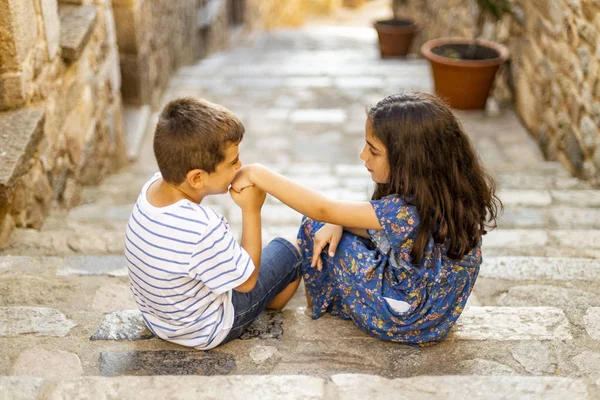 Kleine jongen zoenen de hand van een meisje op een trap — Stockfoto