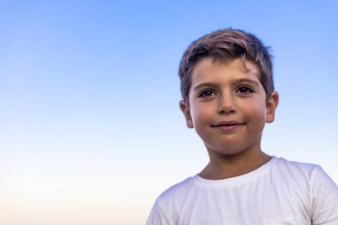 Mavi gökyüzüne karşı küçük bir çocuğun güzel yüzü