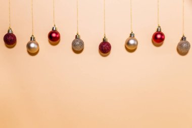 Bej bir arka planda asılı Noel topları. Chistmas kavramı.