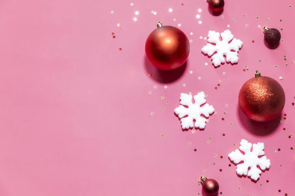 Χριστούγεννα μπάλες και νιφάδες χιονιού σε κόκκινο φόντο — Φωτογραφία Αρχείου