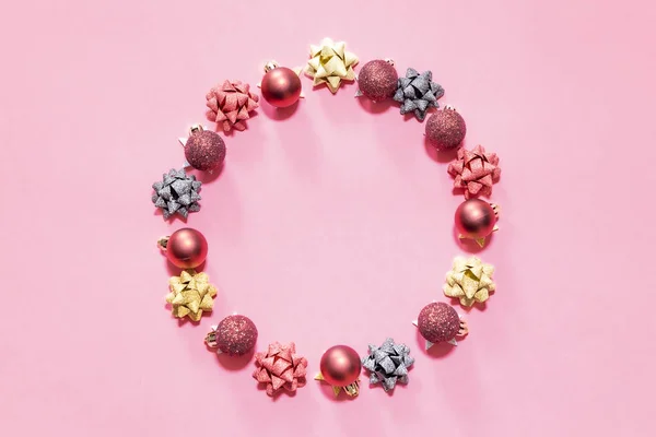 圣诞装饰品形成一个粉红色背景的圆圈 — 图库照片