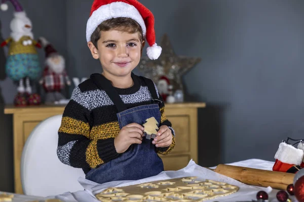 Niño feliz mostrando una galleta cruda en el día de Navidad — Foto de Stock