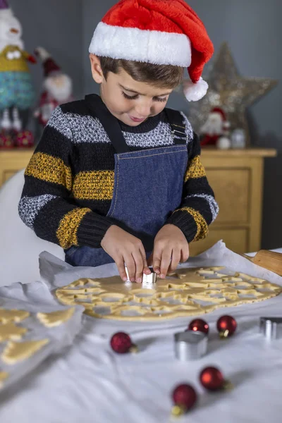 Cute dziecko robi ciasteczka z kształtami na Boże Narodzenie — Zdjęcie stockowe