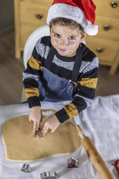 Lindo niño haciendo galletas con formas en el día de Navidad — Foto de Stock