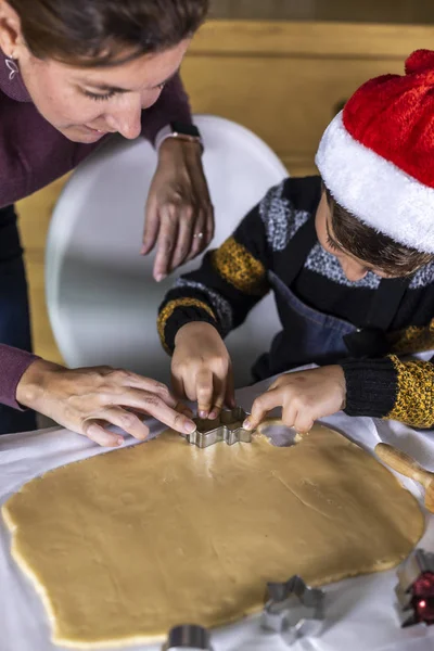 Madre e hijo haciendo galletas con formas el día de Navidad — Foto de Stock