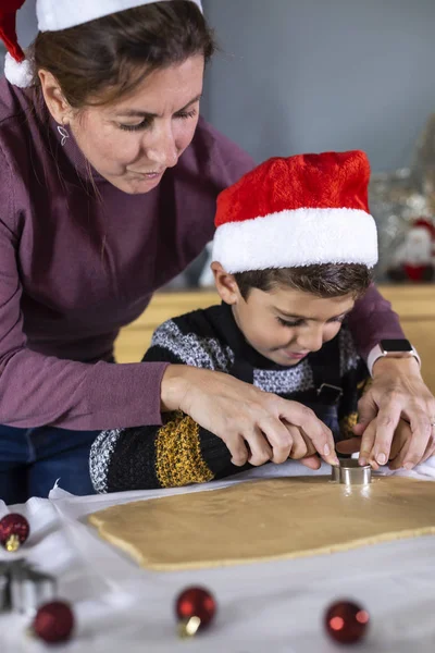Madre e hijo haciendo galletas con formas el día de Navidad — Foto de Stock