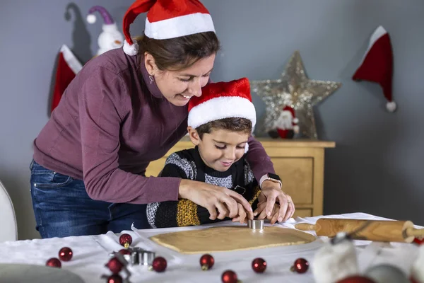 Madre e hijo haciendo galletas con formas el día de Navidad — Foto de Stock