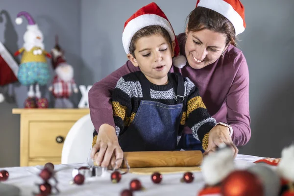 Pequeño niño y su madre haciendo galletas el día de Navidad — Foto de Stock