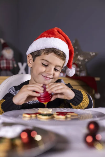 Lindo niño decorando galletas en tiempo de Navidad — Foto de Stock