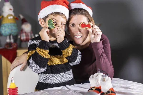 Madre e hijo mostrando galletas decoradas en Navidad — Foto de Stock