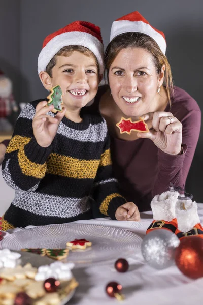 Madre e hijo mostrando galletas decoradas en Navidad — Foto de Stock