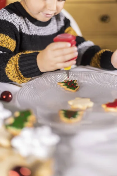 Lindo niño decorando galletas en tiempo de Navidad — Foto de Stock