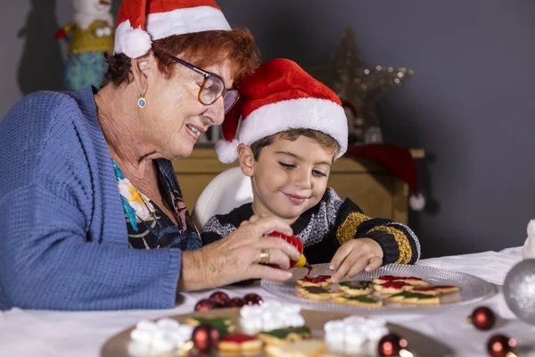 Abuela y nieto decorando galletas en Navidad — Foto de Stock