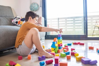 Evdeki bloklarla oynayan komik çocuk.