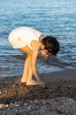 Denizde kabuk tutan küçük bir kız