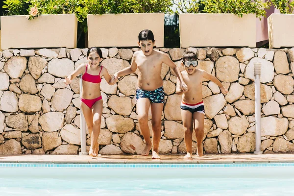 Três Crianças Pulando Uma Piscina — Fotografia de Stock