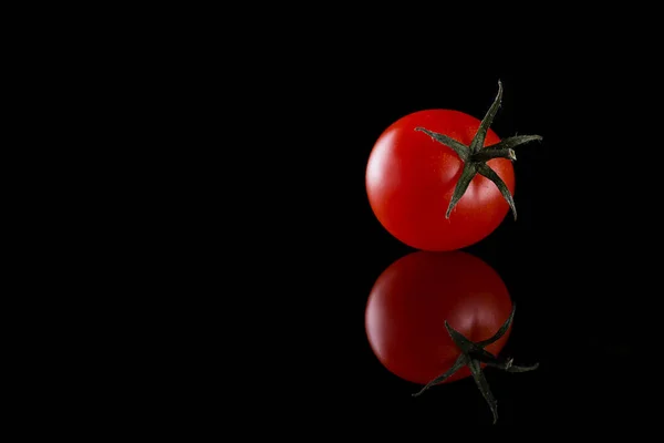 Tomate cerise fraîche isolée sur fond noir avec réflexion, concept d'alimentation saine, image horizontale avec espace pour le texte. — Photo