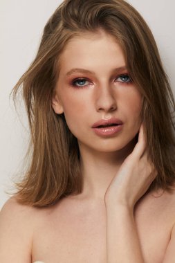 Gri arka planda, temiz ve taze derili güzel bir kadın yüzü var. Güzellik portresi. Mükemmel taze deri. Saf güzellik modeli. Gençlik ve cilt bakımı kavramı