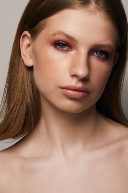 Gri arka planda, temiz ve taze derili güzel bir kadın yüzü var. Güzellik portresi. Mükemmel taze deri. Saf güzellik modeli. Gençlik ve cilt bakımı kavramı