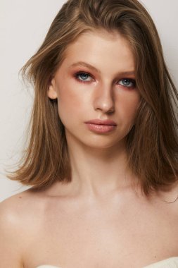 Gri arka planda, temiz ve taze derili güzel bir kadın yüzü var. Güzellik portresi. Mükemmel taze deri. Saf güzellik modeli. Gençlik ve cilt bakımı kavramı