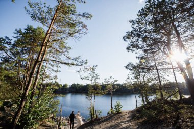 Çift göle doğru yürür. Kozalaklı ormanda..
