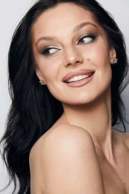 Gri arka planda, temiz ve taze derili güzel bir kadın yüzü var. Güzellik portresi. Mükemmel taze deri. Farklı duygularda model olmak. Gençlik ve cilt bakımı kavramı