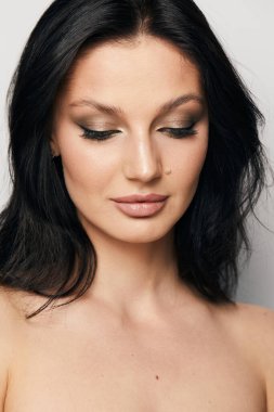 Gri arka planda, temiz ve taze derili güzel bir kadın yüzü var. Güzellik portresi. Mükemmel taze deri. Farklı duygularda model olmak. Gençlik ve cilt bakımı kavramı