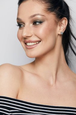 Gri arka planda, temiz ve taze derili güzel bir kadın yüzü var. Güzellik portresi. Mükemmel taze deri. Farklı duygularda model olmak. Gençlik ve cilt bakımı kavramı