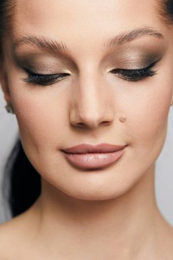 Gri arka planda, temiz ve taze derili güzel bir kadın yüzü var. Güzellik portresi. Mükemmel taze deri. Farklı duygularda model olmak. Gençlik ve cilt bakımı kavramı