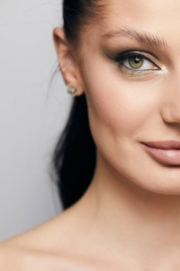 Gri arka planda, temiz ve taze derili güzel bir kadın yüzü var. Güzellik portresi. Mükemmel taze deri. Farklı duygularda model olmak. Gençlik ve cilt bakımı kavramı