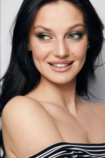 Gri arka planda, temiz ve taze derili güzel bir kadın yüzü var. Güzellik portresi. Mükemmel taze deri. Farklı duygularda model olmak. Gençlik ve cilt bakımı kavramı