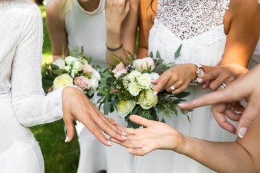 Gelin kızlara alyansla böbürleniyor. Parmağında alyans olan birini gösteriyorlar.