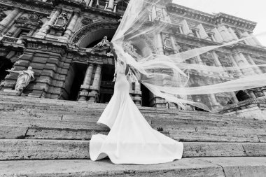 Gelin merdivenlerde dururken peçesini sallıyor. Mimari.