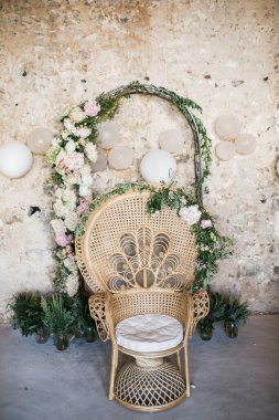 Çiçeklerle süslenmiş saman sandalye. Düğün yerinin güzel çiçek süslemesi ve tören, detaylar.