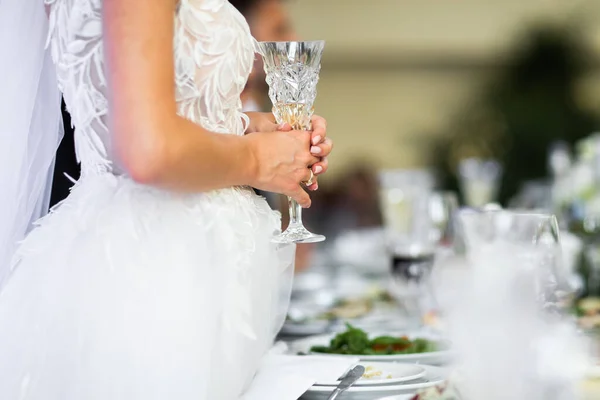 花嫁はテーブルに立ってガラスを持っている — ストック写真