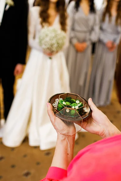 结婚戒指装在玻璃盒里 一位年长的妇女手握着她的手 在新婚燕尔的背景下 — 图库照片