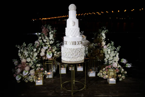 放在桌上的结婚蛋糕 在花的周围外面 — 图库照片
