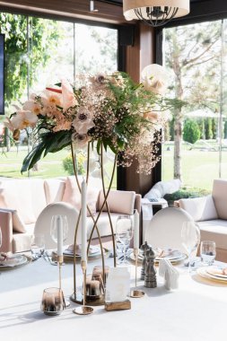 Çatal bıçaklı misafirler için bir masa. Şamdanlarla süslenmiş. Çok güzel dekore edilmiş bir düğün yeri resmi.