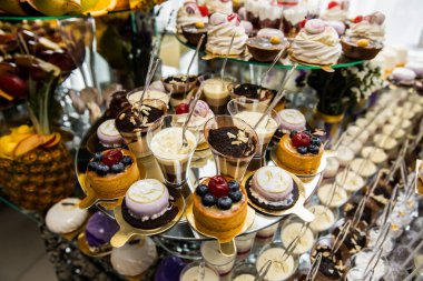 Açık büfede leziz tatlılar. Düğün töreninde bir sürü farklı şekerlemeli çikolata. Tatlı, kurabiye, şeker konseptinin ayrıntıları..