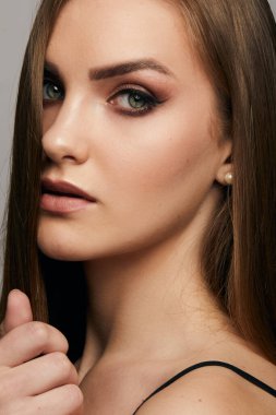 Gri arka planda, temiz ve taze derili güzel bir kadın yüzü var. Güzellik portresi. Mükemmel taze deri. Saf güzellik modeli. Gençlik ve cilt bakımı kavramı