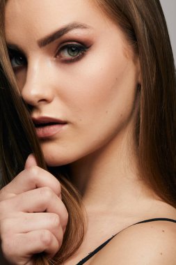 Gri arka planda, temiz ve taze derili güzel bir kadın yüzü var. Güzellik portresi. Mükemmel taze deri. Saf güzellik modeli. Gençlik ve cilt bakımı kavramı