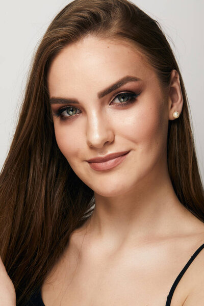 Красивое лицо молодой женщины с чистой свежей кожей вблизи изолированы на сером фоне. Портрет красоты. Идеальная свежая кожа. Чистая модель красоты. Концепция ухода за кожей
