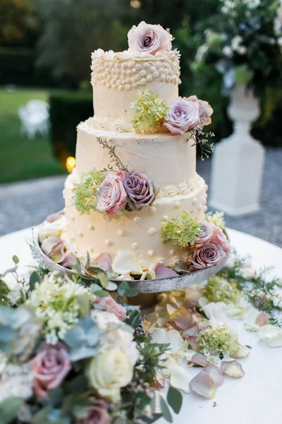 放在桌上的结婚蛋糕 和花在一起里面 — 图库照片